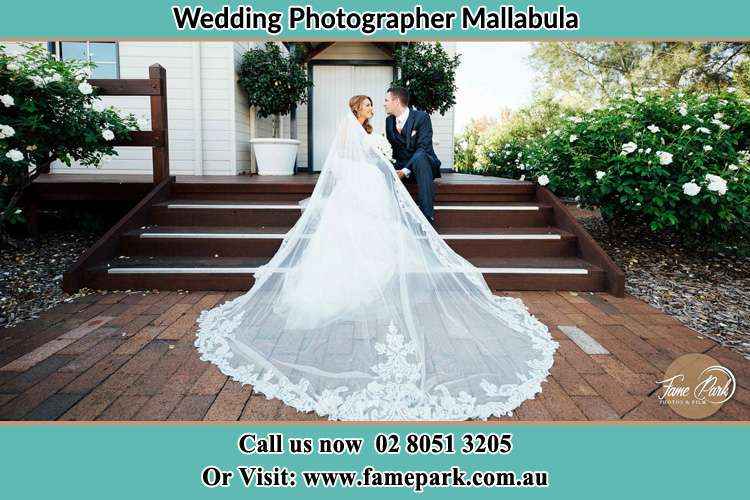 Photo of the Bride and the Groom looking each other while sitting at the staircase Mallabula NSW 2319